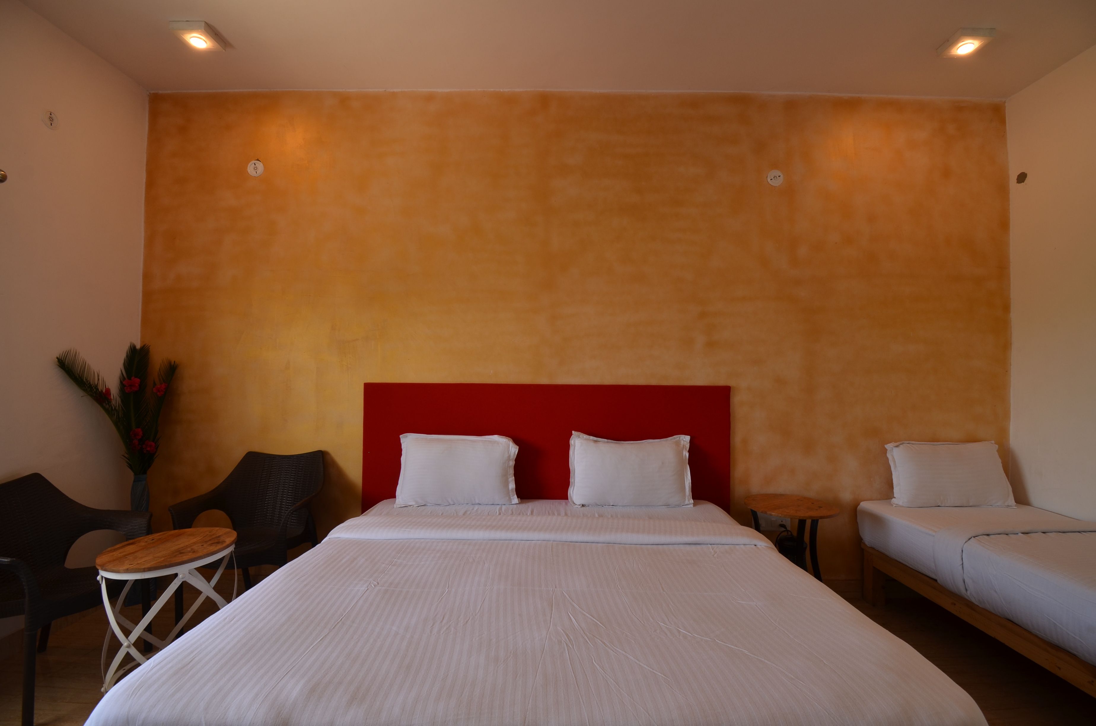A hotel room with a large bed, two bedside tables, a small round table, and two chairs.