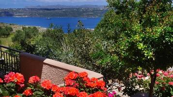 A balcony with a view of a body of water and distant mountains.