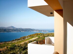 A balcony with a view of a coastal landscape, including a body of water and distant mountains. - Areti Apart Hotel (Chania)