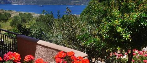 A balcony with a view of a body of water and distant mountains.