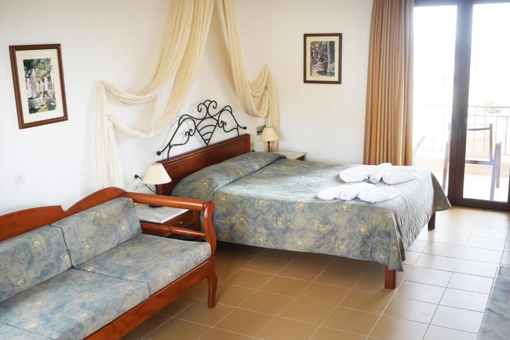 Un dormitorio con cama, sofá y balcón.