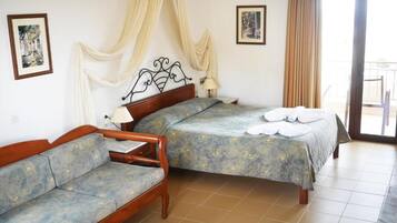 Un dormitorio con cama, sofá y balcón.