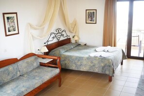 A bedroom with a bed, a sofa, and a balcony. - Areti Apart Hotel (Chania)