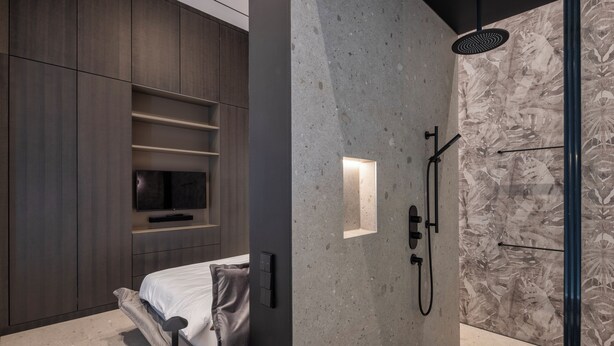 Ein modernes Badezimmer mit Dusche, integriertem Fernseher und minimalistischem Design.