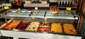 A buffet with various food items including hot dogs, sausages, and baked goods. - Riviera Hotel Mamaia (Constanta)