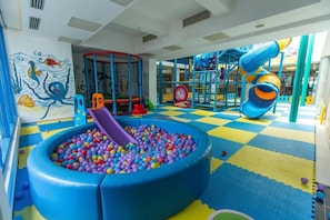 Ein Kinderspielbereich mit Bällebad, Rutschen und Klettergerüsten.