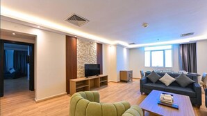 A modern living room with a sofa, television, and a coffee table. - Saray Mushereib Hotel (Doha)