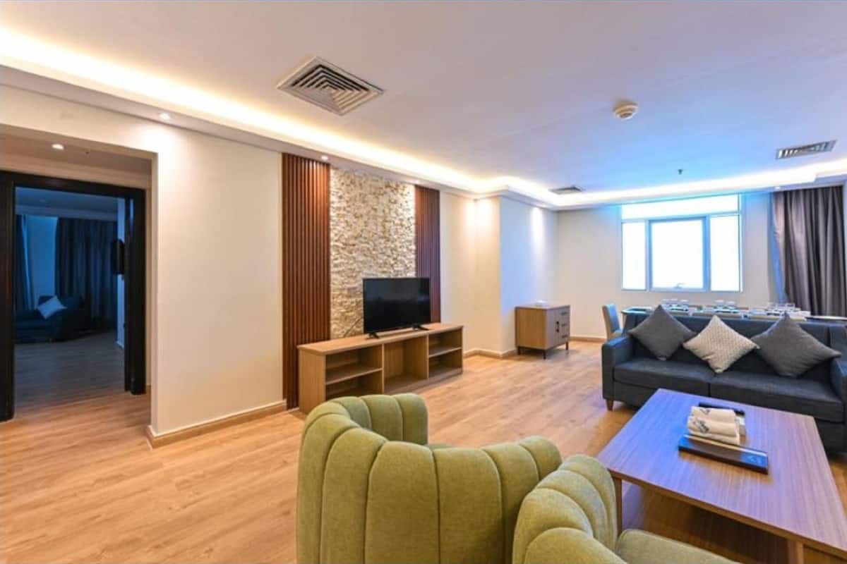 Una sala de estar moderna con sofá, televisión y una mesa de centro.
