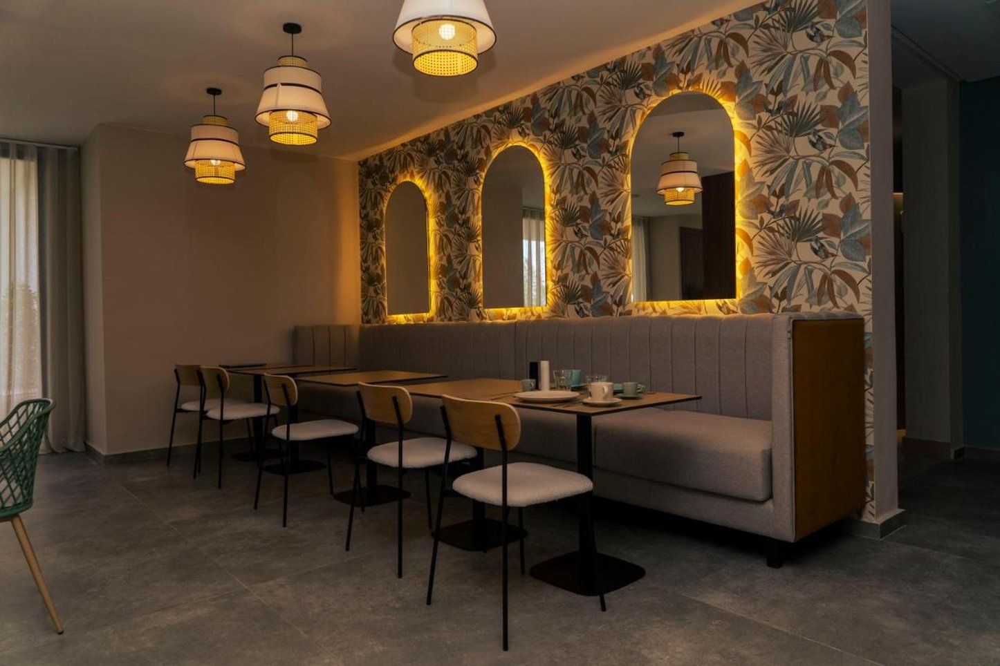 Ein Restaurantinnenraum mit einer langen Theke, mehreren Stühlen und drei Pendelleuchten.