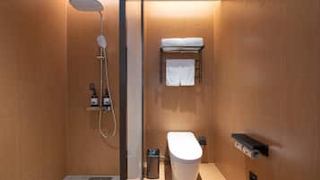 A modern bathroom with a shower, toilet, and towel rack.