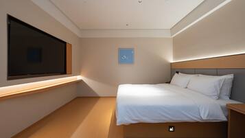 A modern bedroom with a large window, a bed, a bedside table, and a wall-mounted TV.