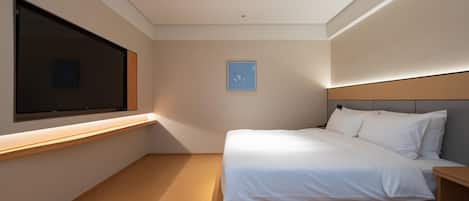 Ein modernes Schlafzimmer mit großem Fenster, einem Bett, einem Nachttisch und einem an der Wand befestigten Fernseher.