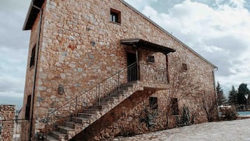 A stone building with a staircase leading to a balcony.