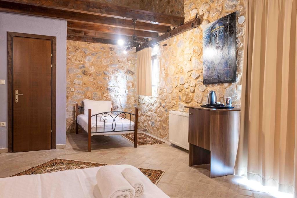 Un dormitorio con pared de piedra, cama de madera, mesita de noche y radiador.