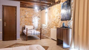 Un dormitorio con pared de piedra, cama de madera, mesita de noche y radiador.
