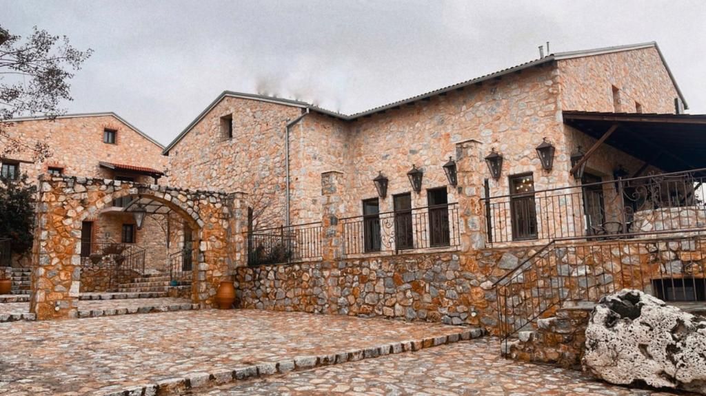 A stone building with a courtyard, a staircase, and a metal railing.