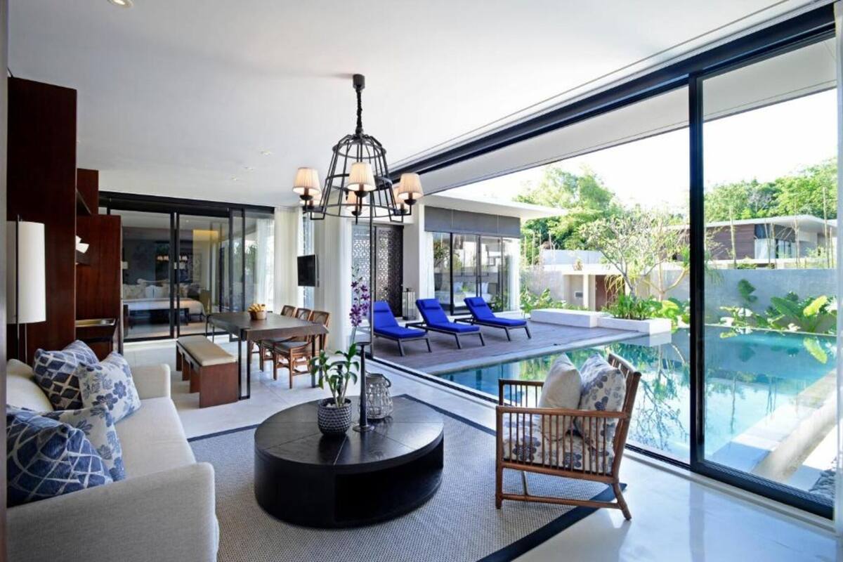 A modern living room with a pool, a dining area, and a view of the outdoors.