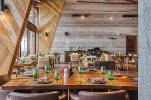 A restaurant with wooden interior, multiple dining tables, and chairs. - Ngorongoro Lodge Melia Collection (Ngorongoro)