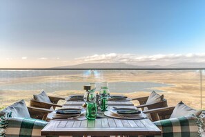 A dining table set with plates, cutlery, and glassware, overlooking a scenic landscape. - Ngorongoro Lodge Melia Collection (Ngorongoro)