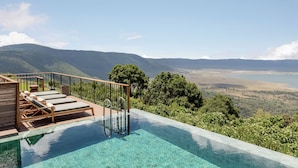 A pool with clear water, wooden deck, and lounge chairs. - Ngorongoro Lodge Melia Collection (Ngorongoro)