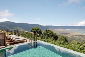 A pool with clear water, wooden deck, and lounge chairs. - Ngorongoro Lodge Melia Collection (Ngorongoro)