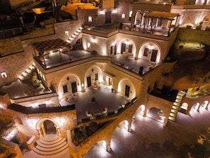 A multi-level courtyard with stone walls, arched doorways, and outdoor seating areas. - Signature Cave Cappadocia Trademark Col by Wyndham (Ürgüp)