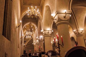 An interior with arched ceilings, chandeliers, and candle-lit tables. - Signature Cave Cappadocia Trademark Col by Wyndham (Ürgüp)