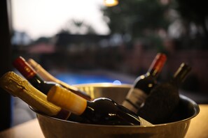 Un seau en métal contenant plusieurs bouteilles de vin, fermées par des bouchons.