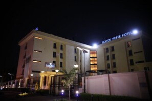 A hotel with a sign reading 'Bolton White Hotel,' a gated entrance, and a well-lit facade. - Bolton White Hotel - Abuja (Abuja)