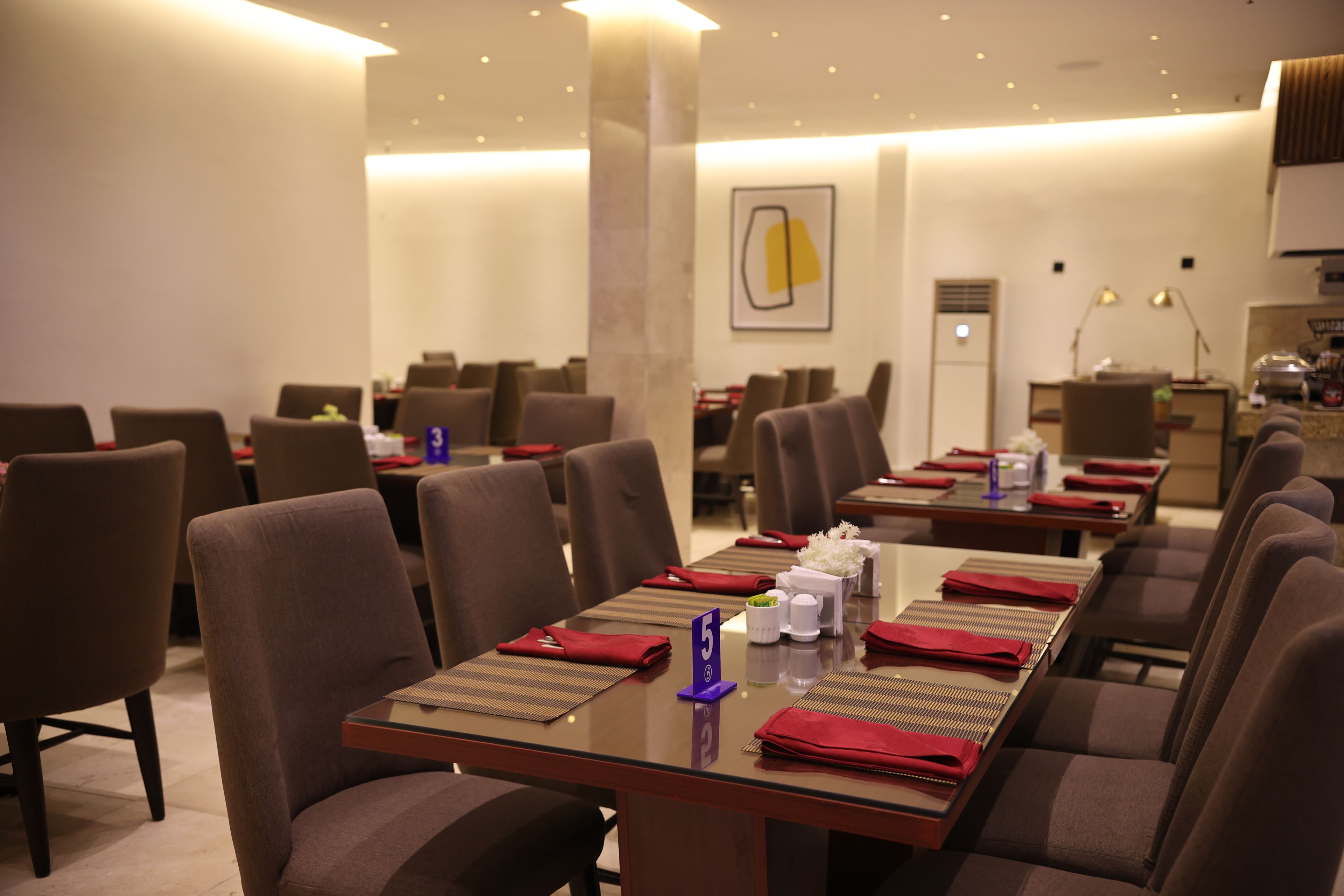 A conference room with tables set for meetings, equipped with nameplates and notepads.