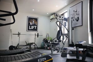 A gym with weightlifting equipment, a treadmill, and exercise machines. - Bolton White Hotel - Abuja (Abuja)