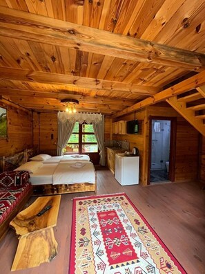 A wooden cabin with a bed, a small kitchenette, and a bathroom. - Teona Bungalov (Findikli)