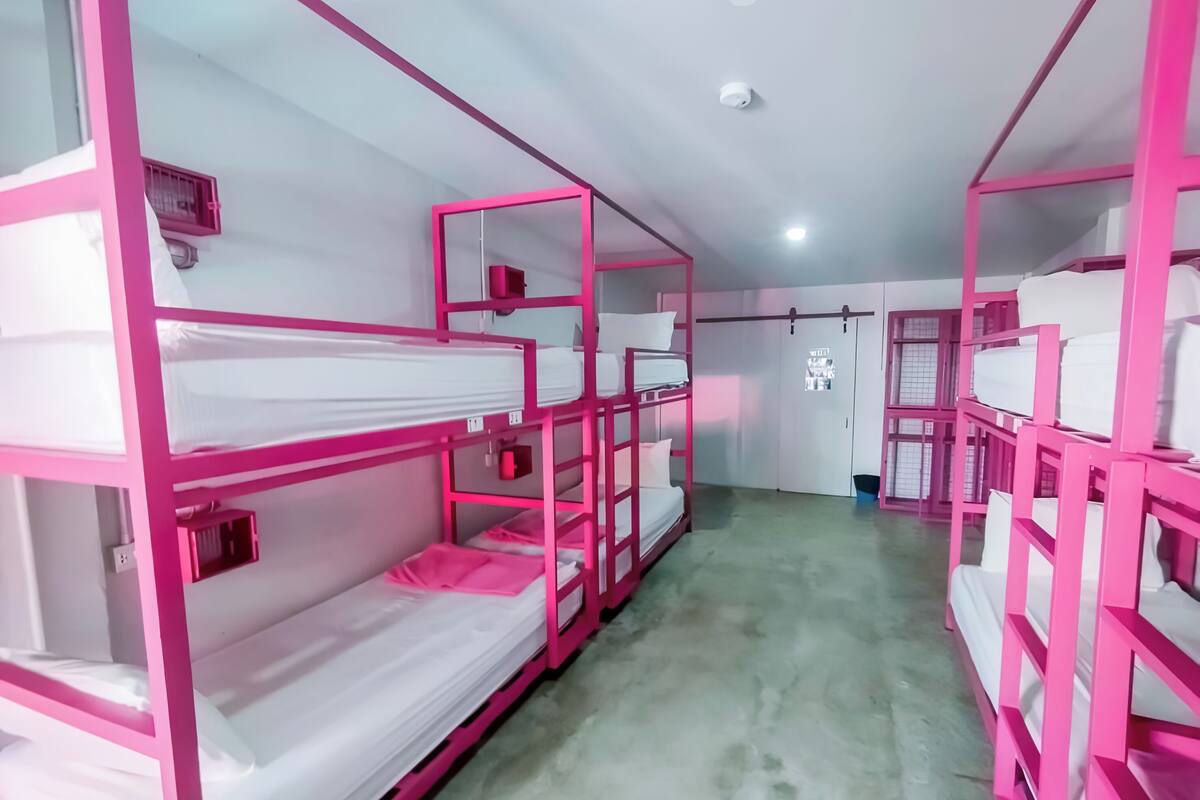 Quarto com beliches, um armário e uma porta com pôster.