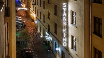A nighttime view of a street lined with buildings, including a hotel with illuminated signage.