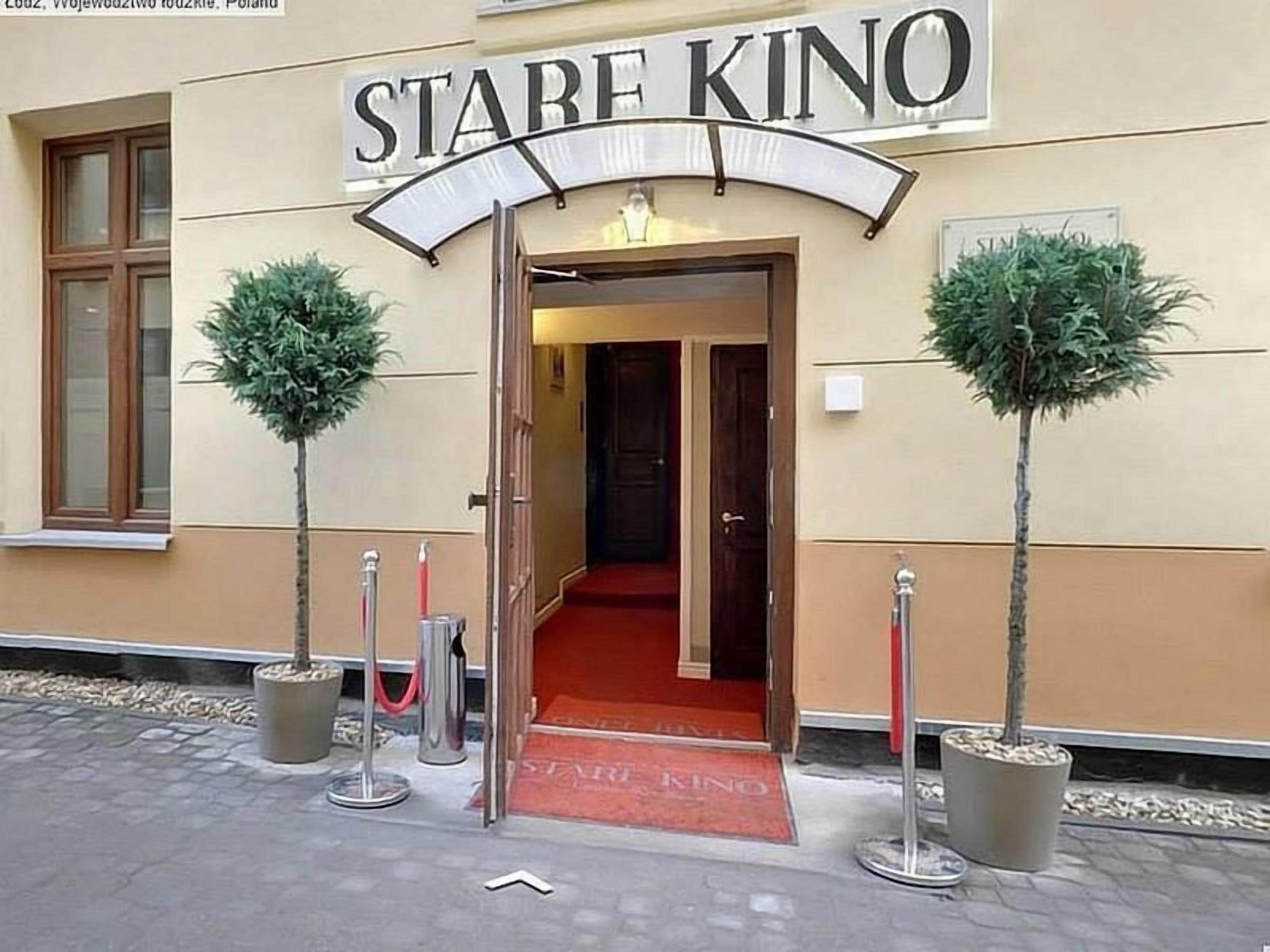 A hotel entrance with a sign reading 'STABE KINO' and a red carpet leading inside.