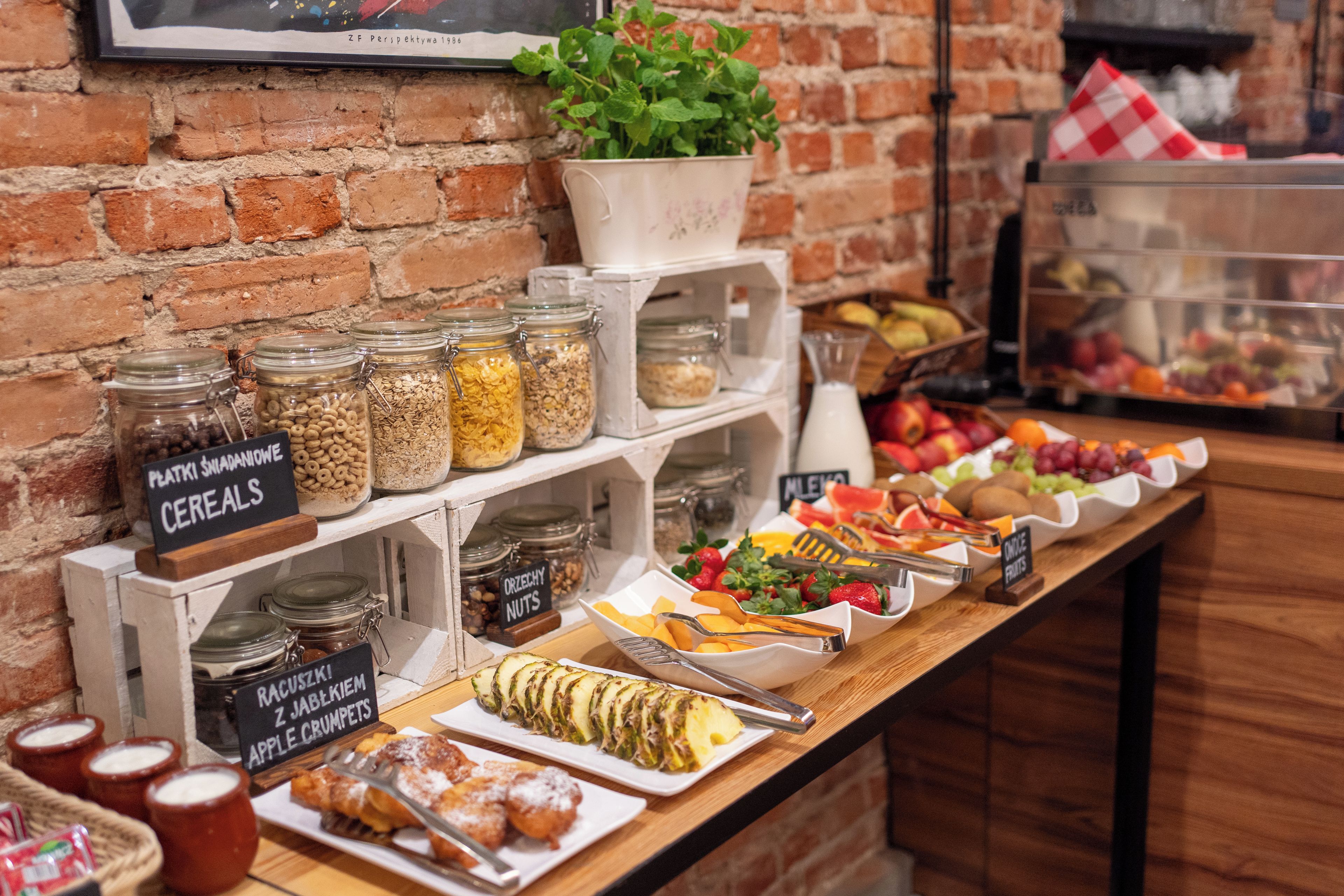 Ein reichhaltiges Frühstücksbuffet mit verschiedenen Speisen, darunter Müsli, Nüsse, Obst und Gebäck.