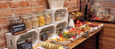 A breakfast buffet with various food options, including cereals, nuts, fruits, and pastries.