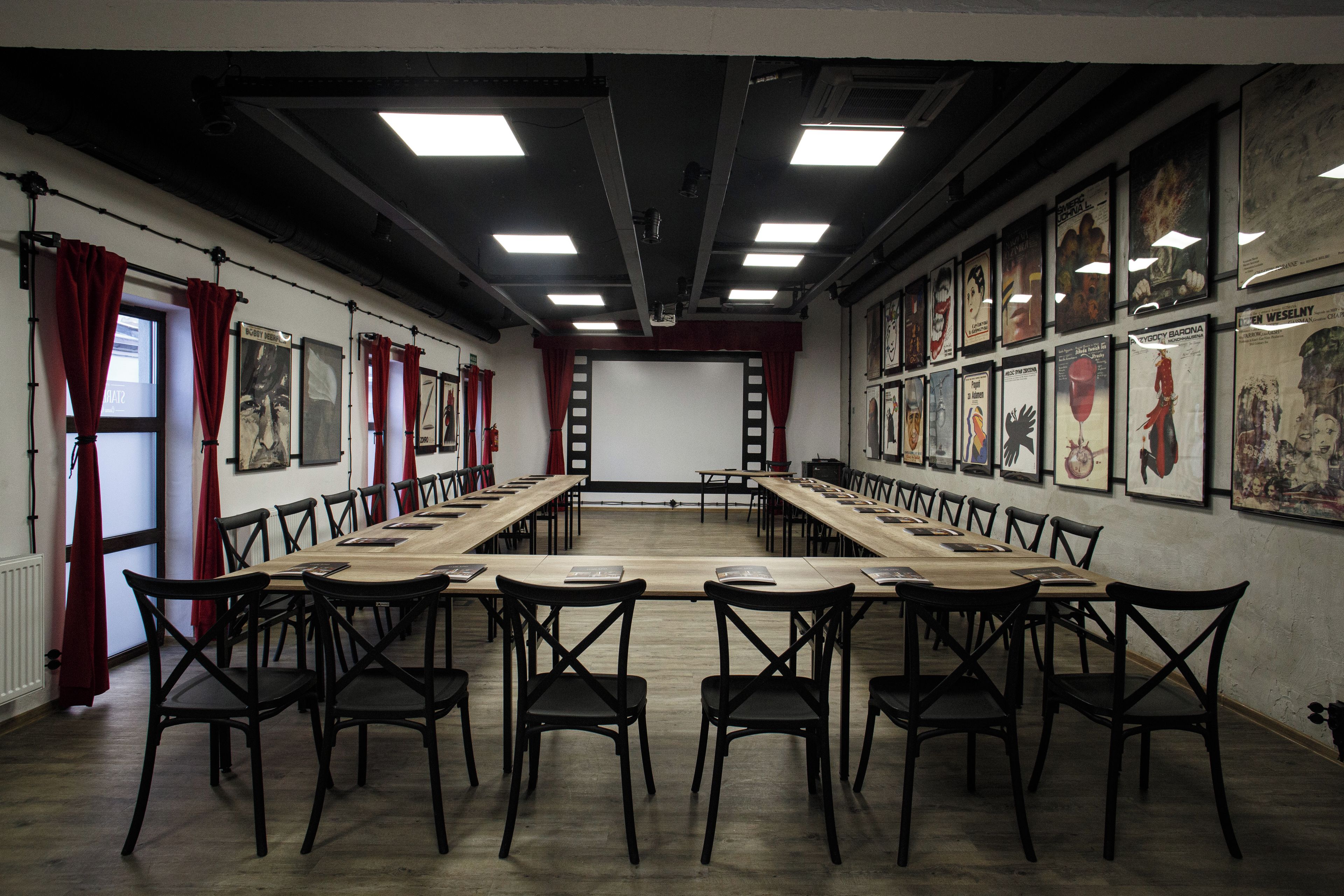 A conference room with a long table, chairs, and framed artwork on the walls.