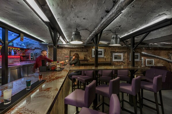A bar area with a bartender, purple bar stools, and a rustic ceiling. - Cinema Rooms - Piotrkowska (Łódź)