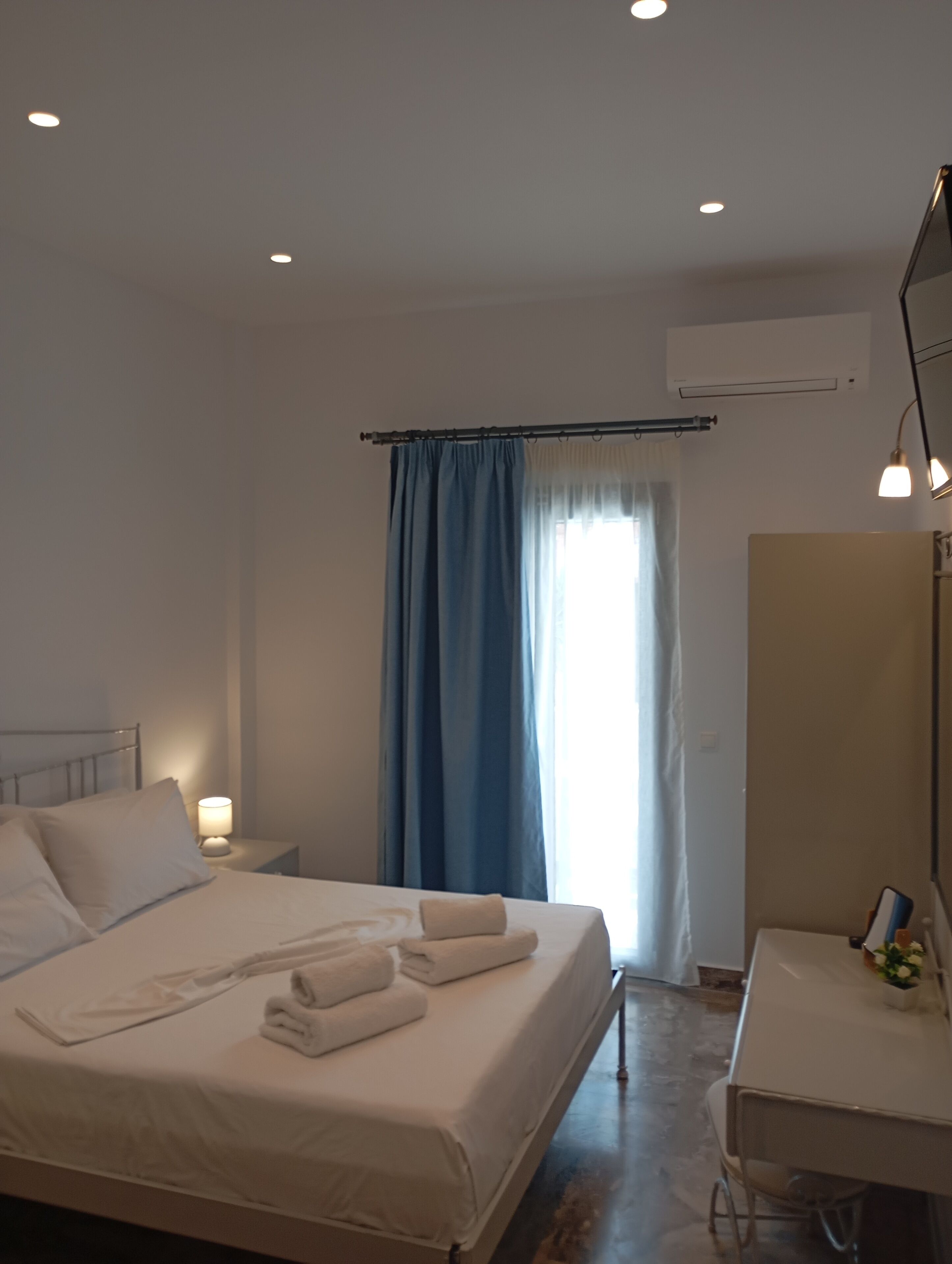 Ein Hotelzimmer mit Bett, Nachttisch, Lampe und Spiegel.