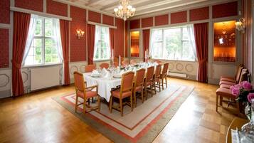 A dining room with a long table set for six, surrounded by wooden chairs.