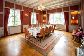 A dining room with a long table set for six, surrounded by wooden chairs.