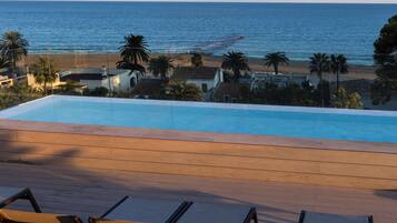 A pool with a view of the beach and ocean.