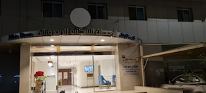 A hotel entrance with a glass facade, a reception desk, and a sign indicating it's a serviced apartment complex. - Golden New Heraa (Jeddah)