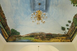 A ceiling with a mural of a landscape and a chandelier. - Juna Mahal Jungle Resort (Sawai Madhopur)