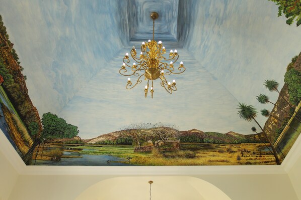 A ceiling with a mural of a landscape and a chandelier. - Juna Mahal Jungle Resort (Sawai Madhopur)