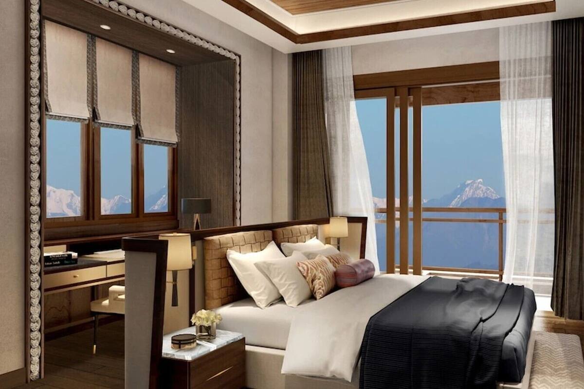 Una habitación de hotel con una cama grande, un escritorio y vistas a una montaña.