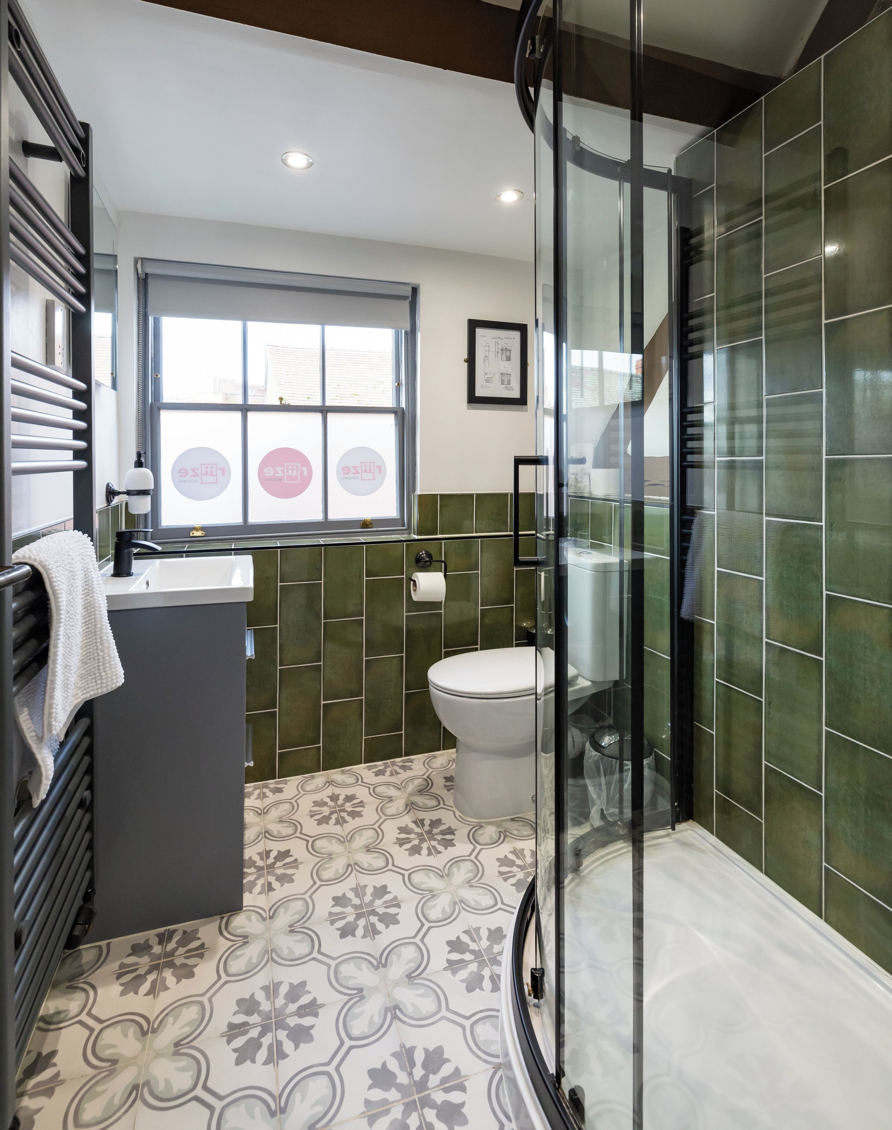 A modern bathroom with a shower, toilet, and sink.