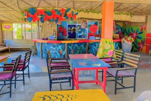 Un espace intérieur coloré, aménagé avec un comptoir, des chaises et des tables.