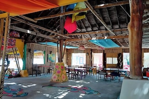 A spacious indoor area with high ceilings, wooden beams, and a variety of seating arrangements. - Chaba Bungalows By Zuzu (Ko Lanta)